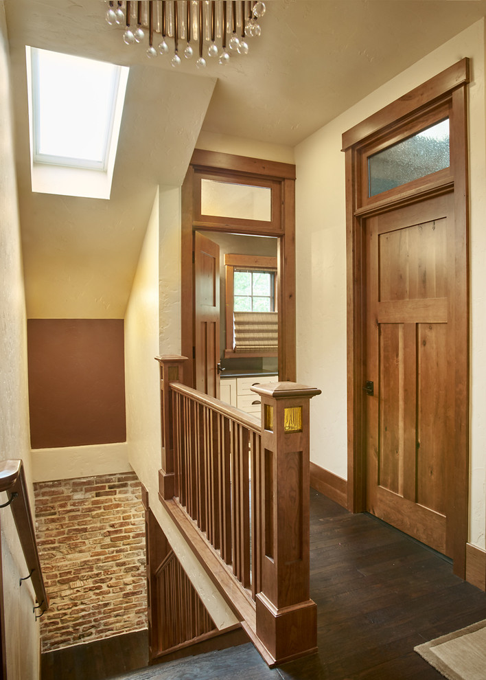 Design ideas for a mid-sized arts and crafts hallway in Denver with beige walls, dark hardwood floors and brown floor.