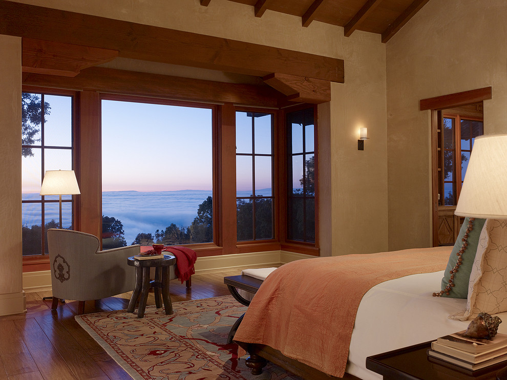 Inspiration for a mediterranean bedroom in San Francisco with beige walls and dark hardwood floors.