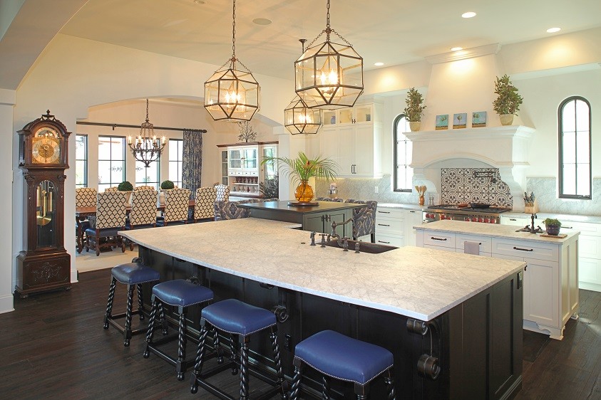 This is an example of a large mediterranean l-shaped kitchen in Tampa with a farmhouse sink, shaker cabinets, white cabinets, marble benchtops, blue splashback, ceramic splashback, stainless steel appliances, dark hardwood floors and multiple islands.