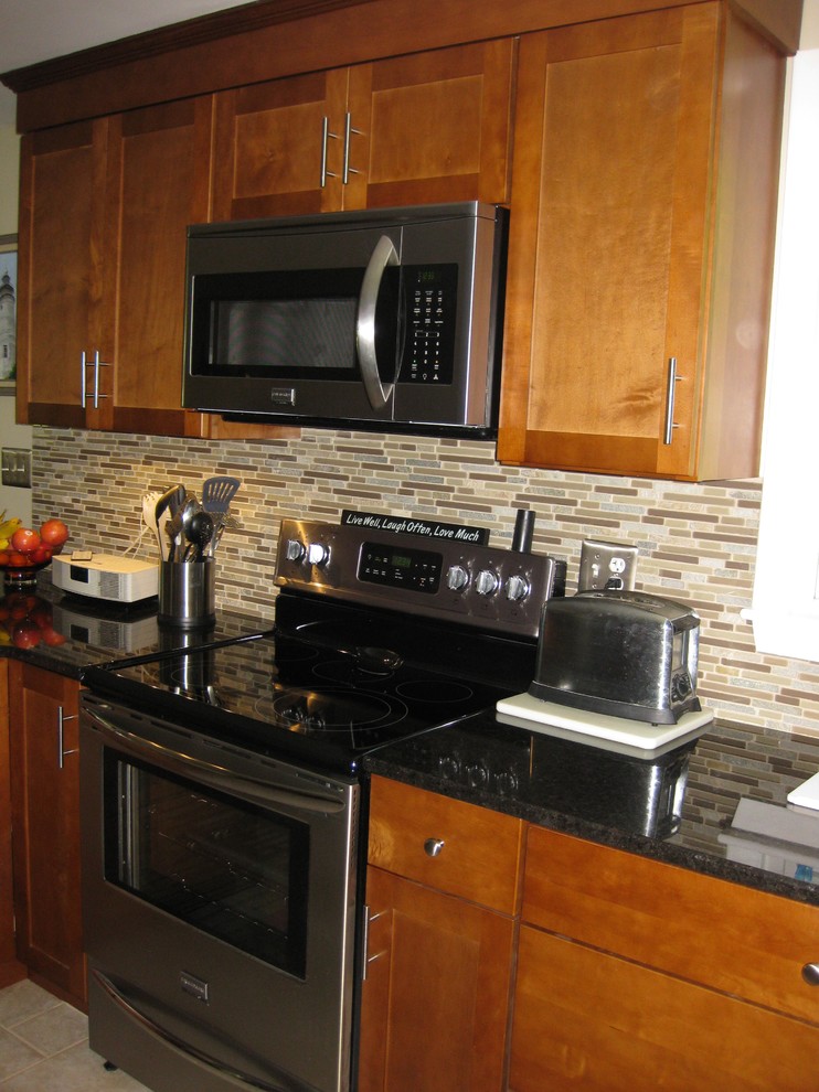 Transitional u-shaped travertine floor and beige floor eat-in kitchen photo in Boston with an undermount sink, medium tone wood cabinets, granite countertops, stainless steel appliances, a peninsula, shaker cabinets, brown backsplash, matchstick tile backsplash and black countertops