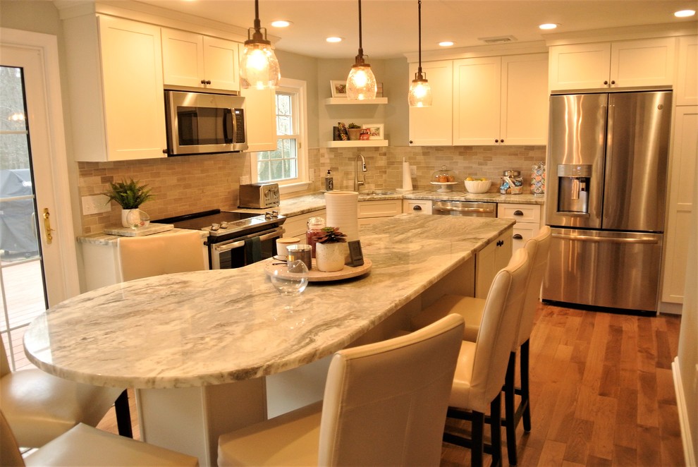 Kitchen - transitional l-shaped medium tone wood floor kitchen idea in Boston with an undermount sink, shaker cabinets, white cabinets, granite countertops, beige backsplash, subway tile backsplash, stainless steel appliances and an island