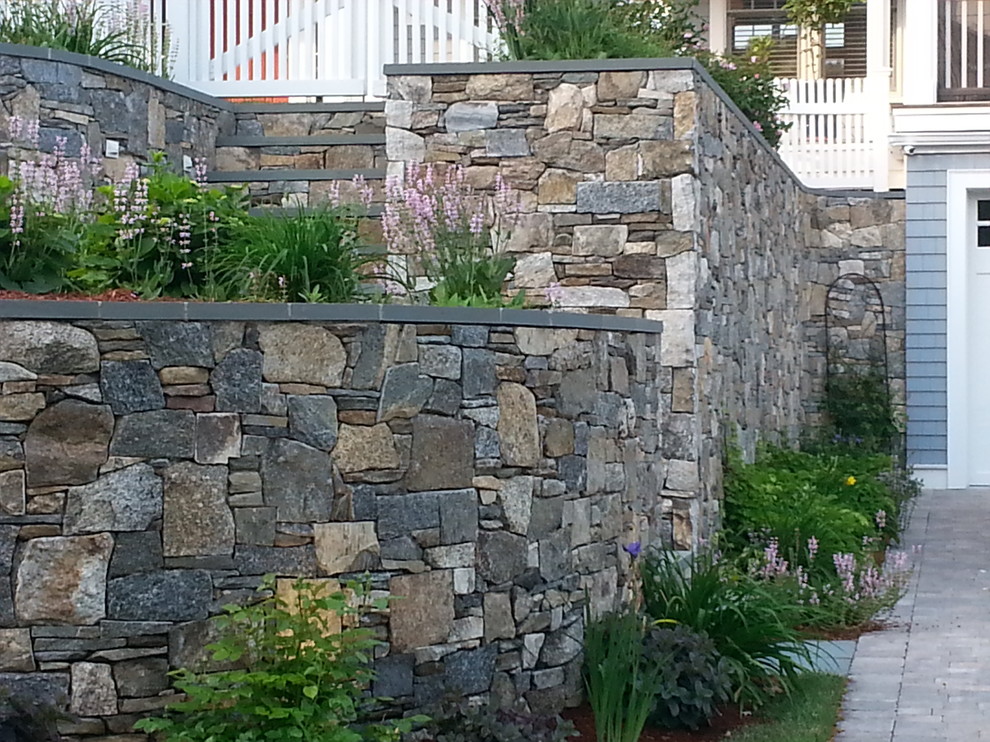 Mid-sized traditional front yard partial sun garden in Boston with a retaining wall and mulch.