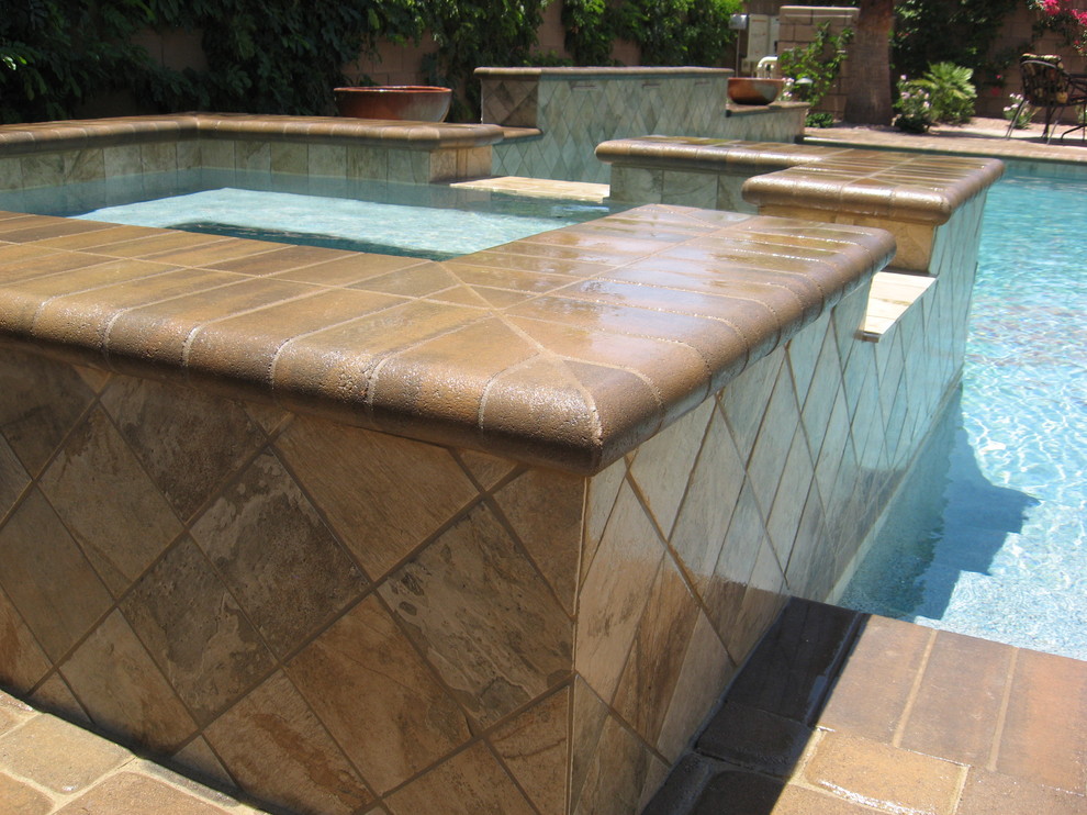 Example of a mid-sized backyard concrete paver hot tub design in Orange County