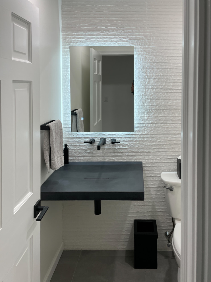 Пример оригинального дизайна: маленькая ванная комната в современном стиле с раздельным унитазом, белой плиткой, плиткой, белыми стенами, полом из керамогранита, душевой кабиной, подвесной раковиной, столешницей из бетона, серым полом, черной столешницей, тумбой под одну раковину и подвесной тумбой для на участке и в саду