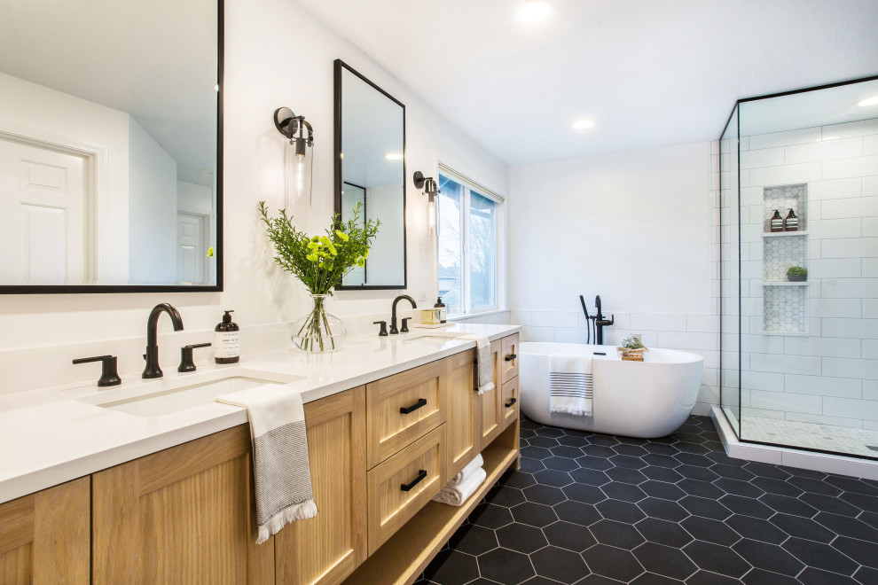 Mid-sized country master bathroom in Seattle with shaker cabinets, a freestanding tub, a corner shower, white tile, subway tile, white walls, porcelain floors, an undermount sink, black floor, a hinged shower door, white benchtops, engineered quartz benchtops, medium wood cabinets, a niche, a double vanity and a built-in vanity.