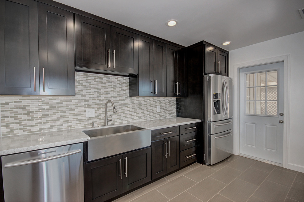 Inspiration for a mid-sized transitional single-wall porcelain tile eat-in kitchen remodel in Phoenix with a farmhouse sink, shaker cabinets, dark wood cabinets, quartz countertops, multicolored backsplash, glass sheet backsplash, stainless steel appliances and an island