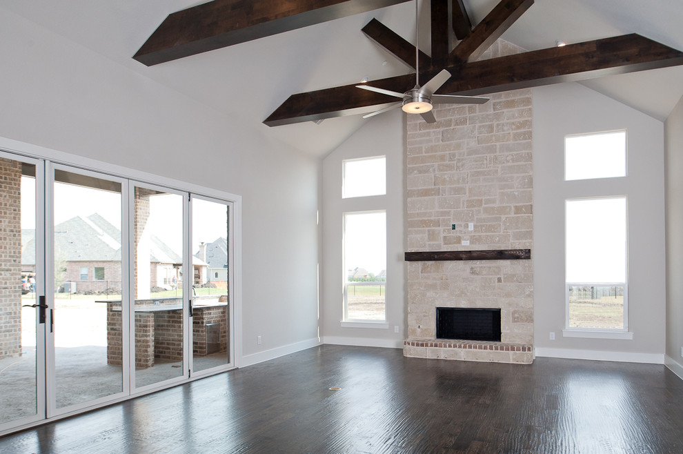 This is an example of a large transitional open concept family room in Dallas with white walls, dark hardwood floors, a standard fireplace, a stone fireplace surround and a wall-mounted tv.