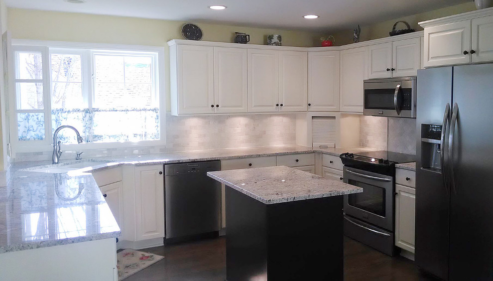 Mid-sized transitional u-shaped dark wood floor kitchen photo in Minneapolis with a double-bowl sink, raised-panel cabinets, white cabinets, granite countertops, white backsplash, ceramic backsplash, stainless steel appliances and an island