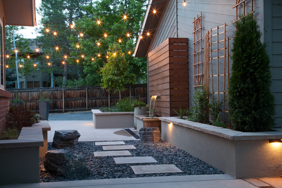 Design ideas for a small modern backyard partial sun garden in Denver with natural stone pavers and a water feature.