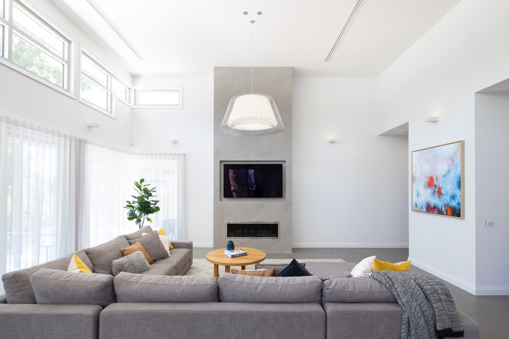 Contemporary living room in Canberra - Queanbeyan with white walls, a ribbon fireplace, a wall-mounted tv and grey floor.