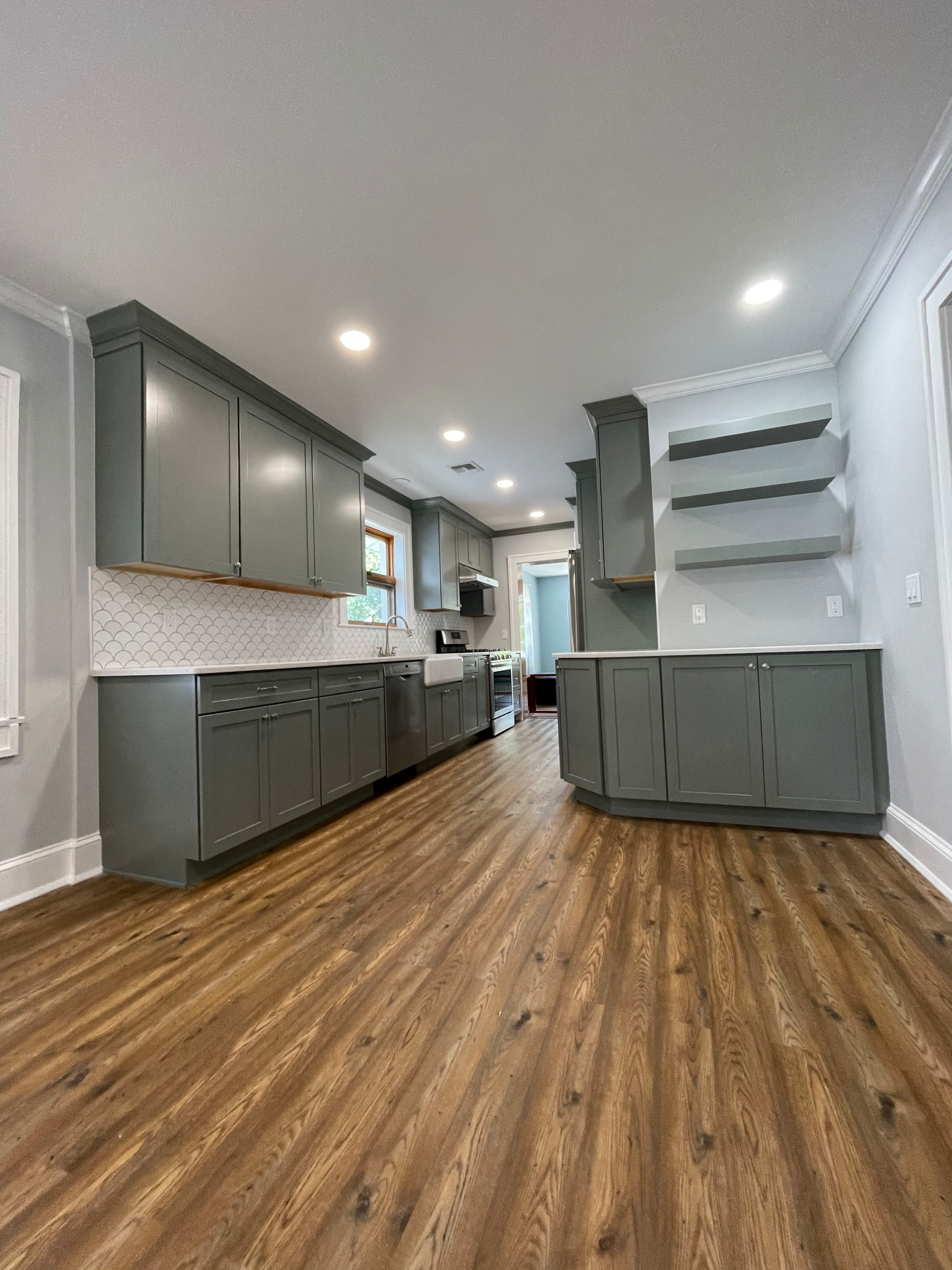 This kitchen has a fresh and casual feeling . Grey cabinets adds unique flare