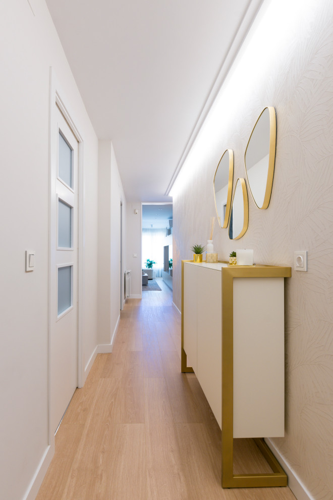 Cette image montre un couloir design de taille moyenne avec un mur beige, sol en stratifié, un sol marron et du papier peint.
