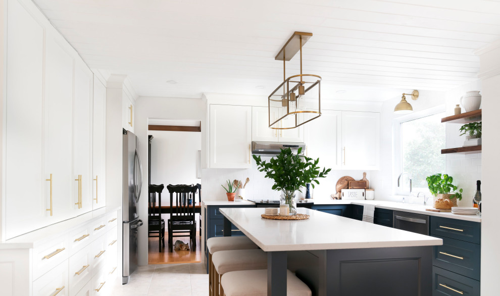 Transitional u-shaped gray floor kitchen photo in Calgary with recessed-panel cabinets, blue cabinets, white backsplash, subway tile backsplash, stainless steel appliances, an island and white countertops