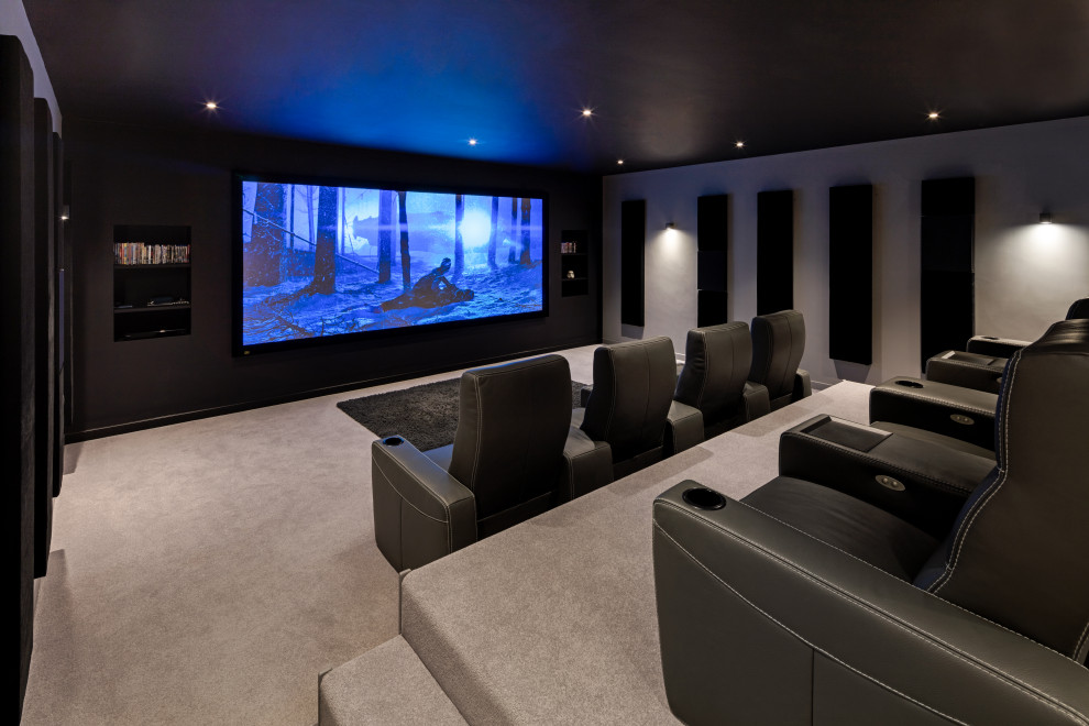 Photo of a large modern enclosed home cinema in Oxfordshire with grey walls, carpet, a projector screen, grey floors and feature lighting.