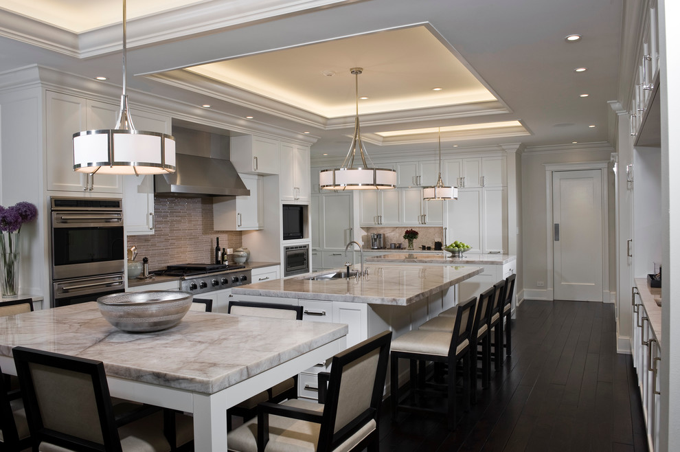 Large contemporary u-shaped kitchen in Chicago with an undermount sink, shaker cabinets, white cabinets, marble benchtops, brown splashback, glass tile splashback, panelled appliances, dark hardwood floors, multiple islands and brown floor.
