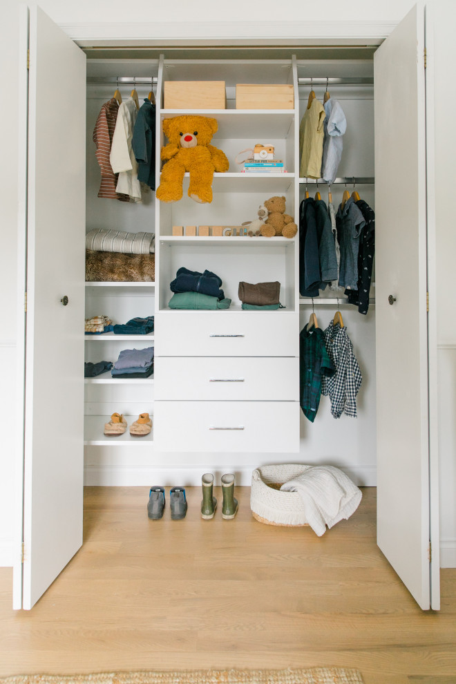 Design ideas for a small classic standard wardrobe in Other with flat-panel cabinets, white cabinets and light hardwood flooring.