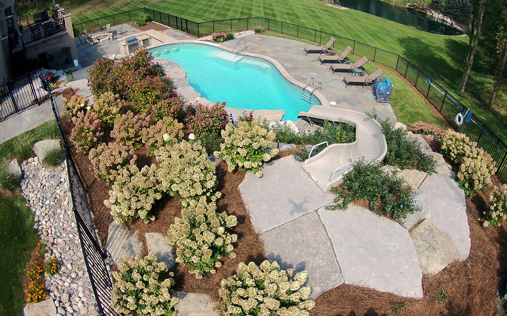 Inspiration for a large transitional backyard stone and custom-shaped water slide remodel in Detroit