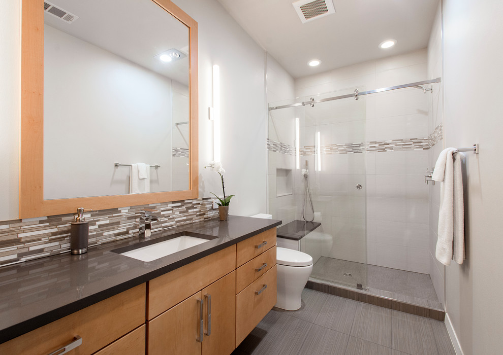 Design ideas for a mid-sized modern master bathroom in Dallas with beige walls, porcelain floors, beige floor, flat-panel cabinets, light wood cabinets, a double shower, a two-piece toilet, white tile, porcelain tile, an undermount sink, engineered quartz benchtops and a sliding shower screen.