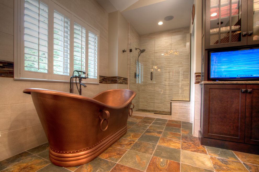 Photo of an expansive arts and crafts master bathroom in St Louis with shaker cabinets, dark wood cabinets, a freestanding tub, an alcove shower, a one-piece toilet, multi-coloured tile, porcelain tile, beige walls, ceramic floors, an undermount sink and quartzite benchtops.