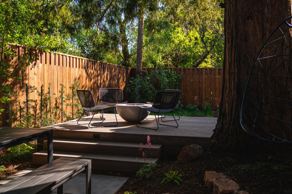 Imagen de jardín moderno pequeño en patio trasero con brasero, exposición parcial al sol, entablado y con madera