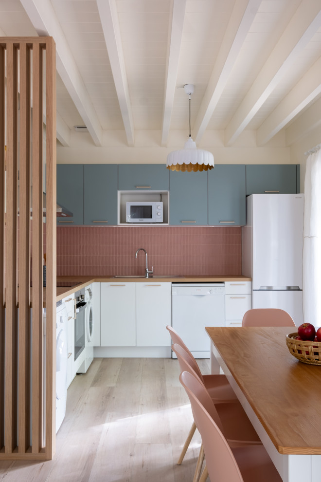 Idée de décoration pour une cuisine blanche et bois nordique de taille moyenne avec un évier 1 bac, un plan de travail en bois, une crédence rose, une crédence en céramique, un électroménager noir, parquet clair et un plan de travail beige.