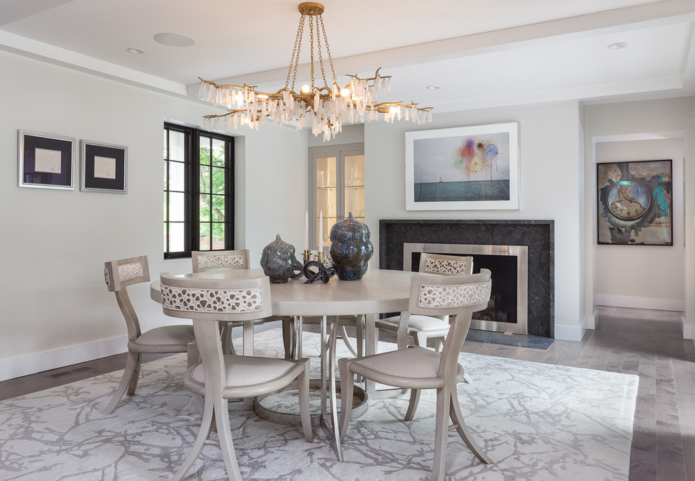 Design ideas for a large transitional separate dining room in Boston with a standard fireplace, a metal fireplace surround, grey walls, brown floor and light hardwood floors.