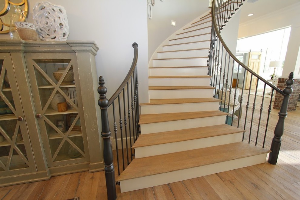 Expansive country wood curved staircase in Salt Lake City with wood risers.