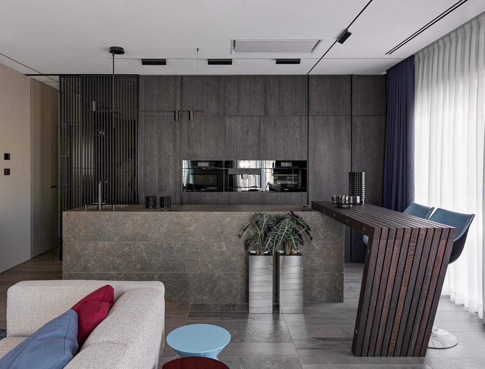 Photo of a contemporary open plan kitchen in Moscow with a single-bowl sink, flat-panel cabinets, dark wood cabinets, black appliances, multiple islands, brown floor and brown benchtop.