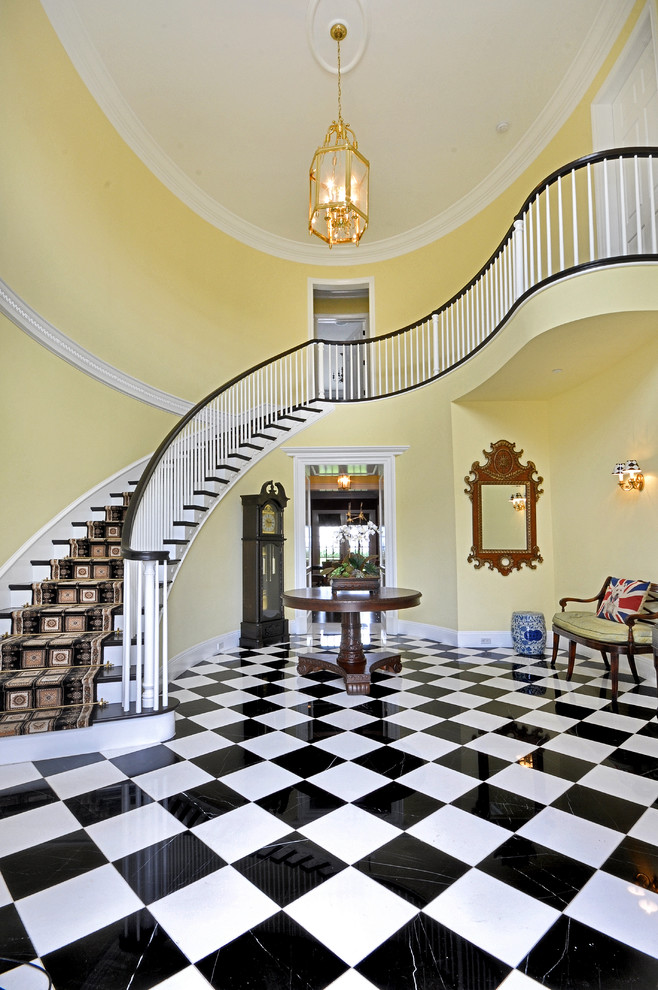 Inspiration for a large traditional foyer in Los Angeles with yellow walls, marble floors, a single front door and a black front door.
