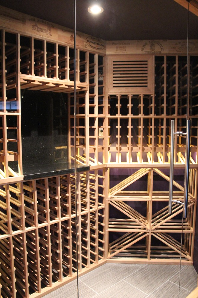 Mid-sized contemporary wine cellar in Toronto with storage racks, ceramic floors and beige floor.