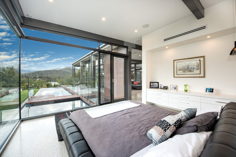 Photo of a contemporary bedroom in Sydney with white walls, concrete floors and grey floor.