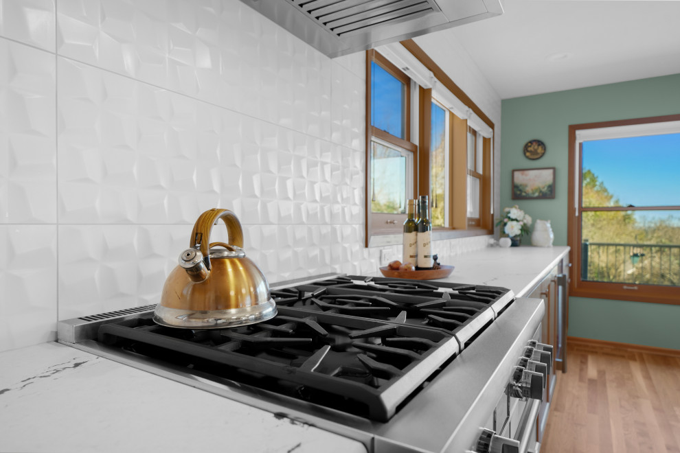Kitchen - transitional l-shaped medium tone wood floor kitchen idea with shaker cabinets, white backsplash, an island and white countertops