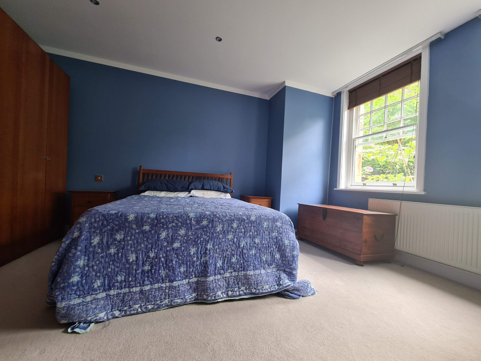Geräumiges Klassisches Hauptschlafzimmer mit blauer Wandfarbe, Teppichboden, beigem Boden und eingelassener Decke in Sonstige