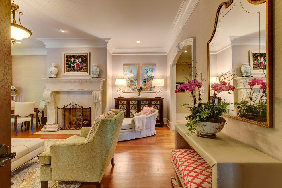 This is an example of a large traditional formal enclosed living room in Raleigh with beige walls, medium hardwood floors, a standard fireplace, a stone fireplace surround and no tv.