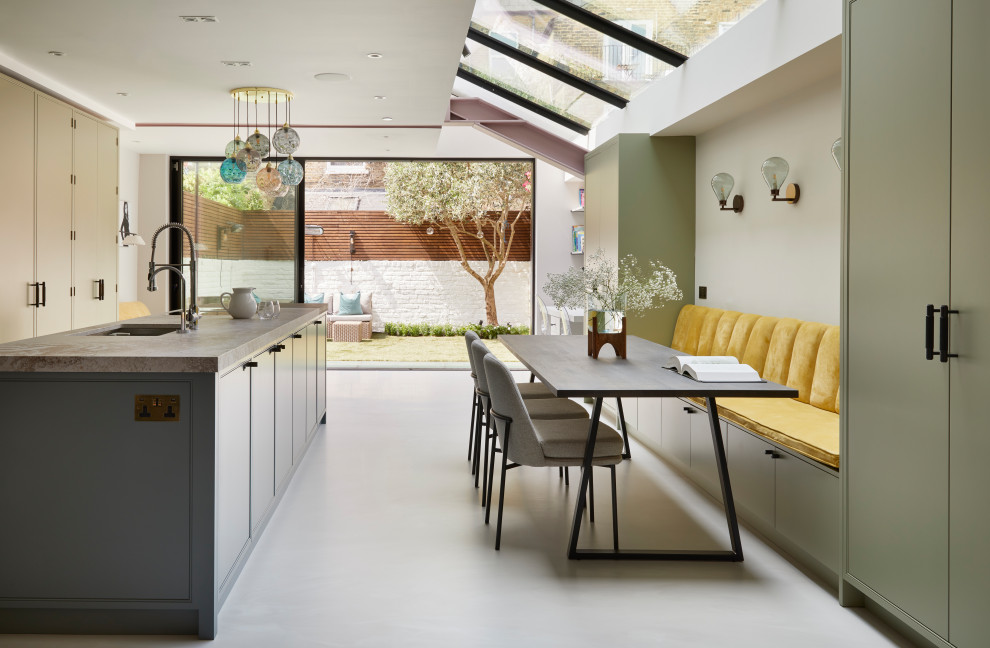 Imagen de cocina lineal moderna grande abierta con armarios con rebordes decorativos, puertas de armario verdes, encimera de cuarcita, una isla y suelo gris