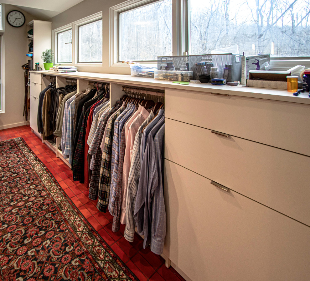 Mid-sized midcentury gender-neutral walk-in wardrobe in Cleveland with flat-panel cabinets, white cabinets, ceramic floors and red floor.