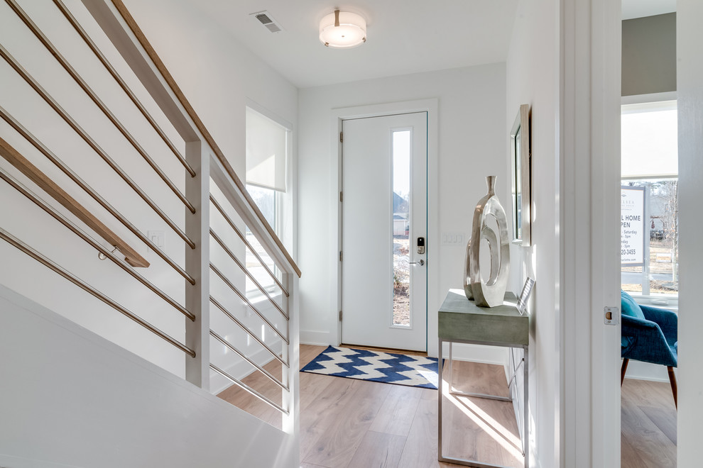 Mid-sized contemporary foyer in Charlotte with white walls, laminate floors, a single front door and brown floor.