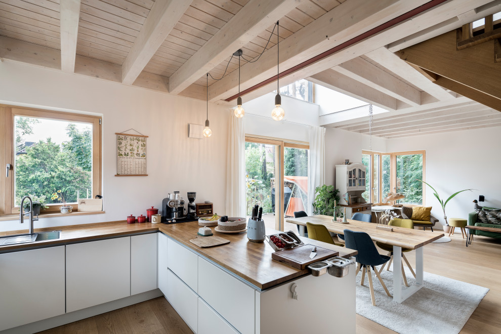 Idee per una sala da pranzo aperta verso la cucina costiera di medie dimensioni con pareti bianche, parquet chiaro, pavimento marrone e travi a vista