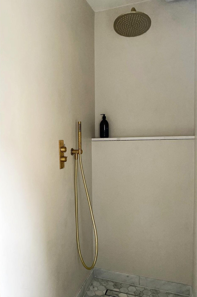 Свежая идея для дизайна: ванная комната среднего размера в современном стиле с инсталляцией, бежевой плиткой, бежевыми стенами, мраморным полом, подвесной раковиной, мраморной столешницей, белым полом и белой столешницей - отличное фото интерьера