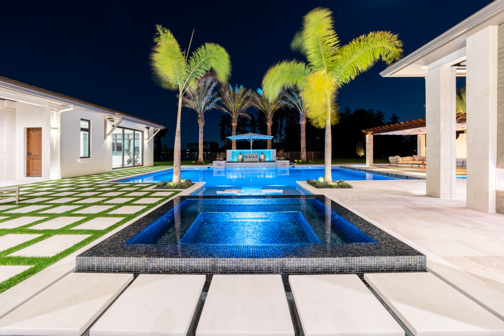 Esempio di un'ampia piscina a sfioro infinito mediterranea personalizzata dietro casa con paesaggistica bordo piscina e piastrelle