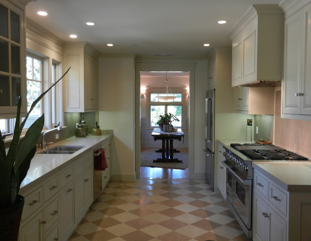 Design ideas for a mid-sized traditional galley separate kitchen in Los Angeles with a double-bowl sink, raised-panel cabinets, white cabinets, quartzite benchtops, beige splashback, stainless steel appliances, linoleum floors and no island.