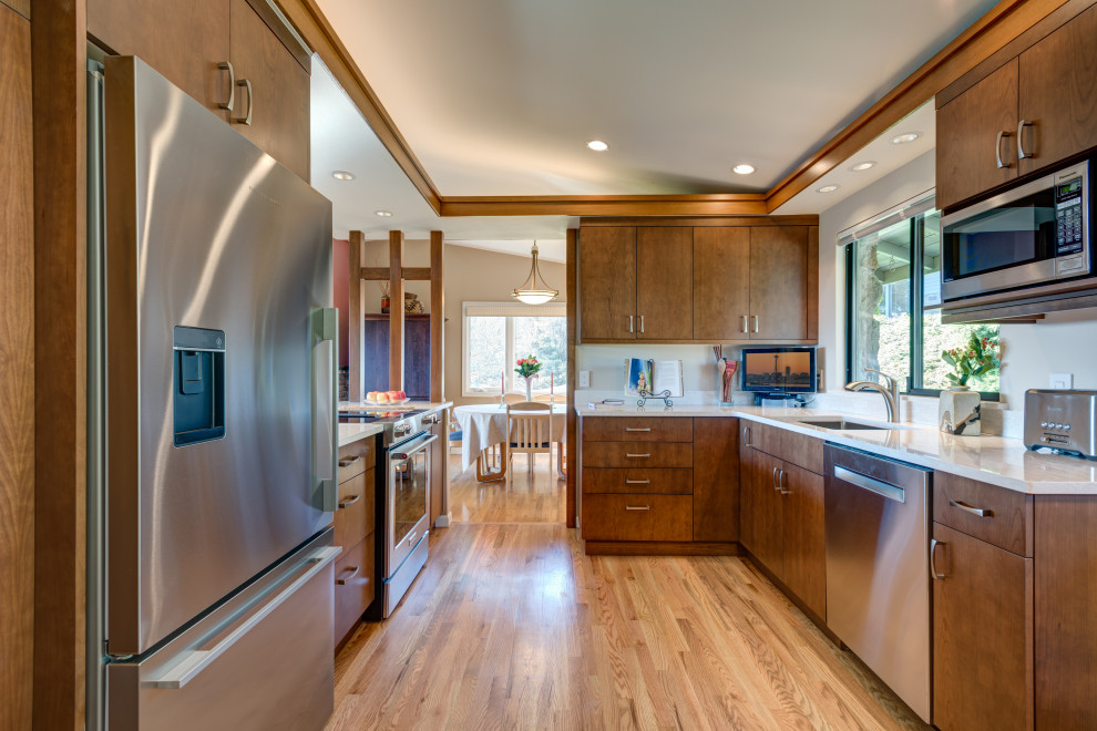 Photo of a small midcentury galley eat-in kitchen in Seattle with an undermount sink, flat-panel cabinets, dark wood cabinets, quartz benchtops, beige splashback, porcelain splashback, stainless steel appliances, porcelain floors, a peninsula, beige floor and white benchtop.