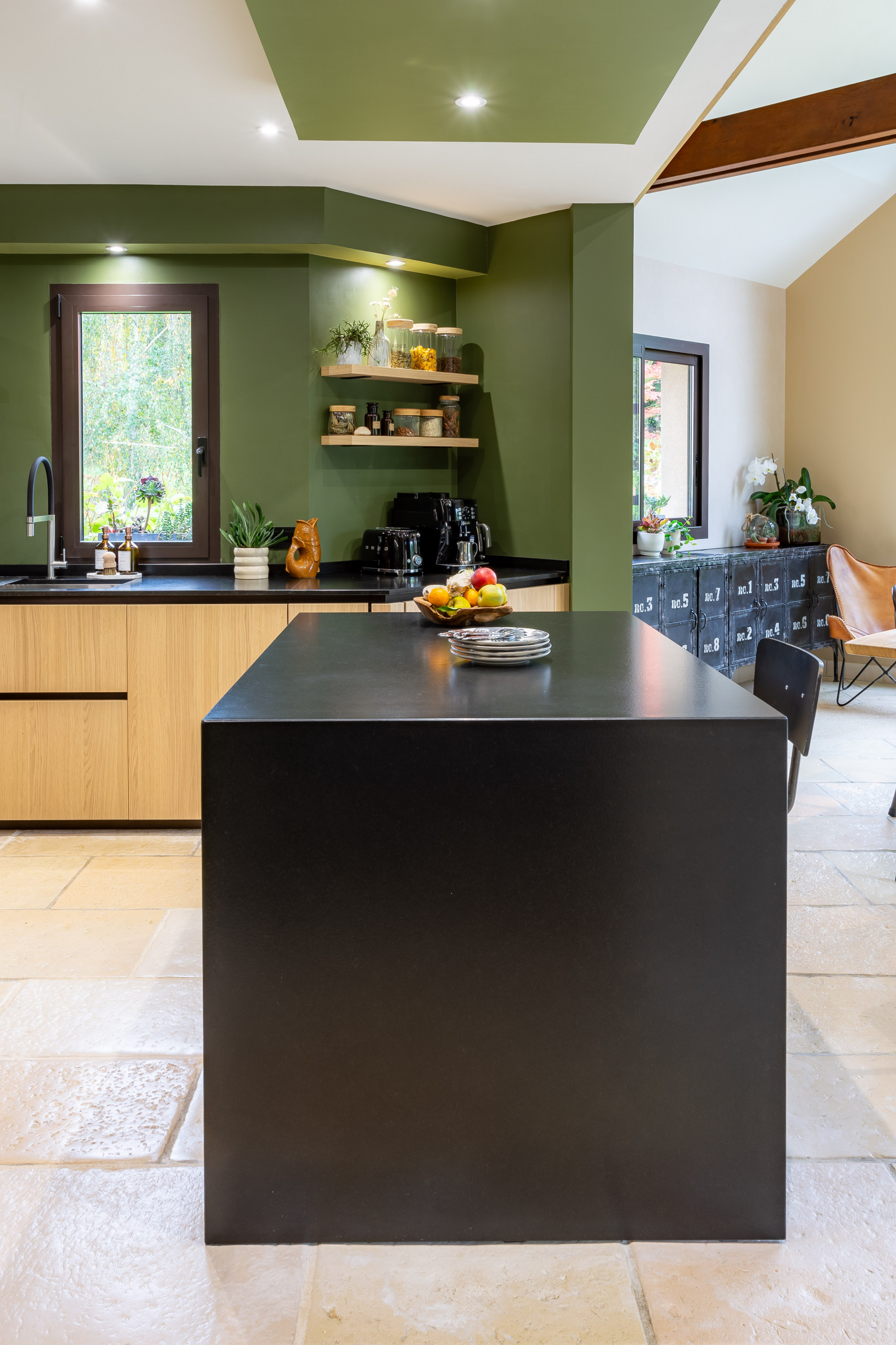 Réalisation d'une cuisine noire et bois dans un écrin végétal