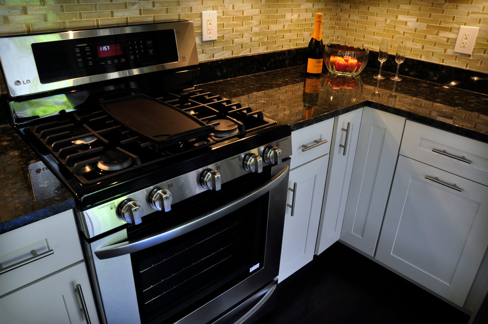 Example of a mid-sized transitional u-shaped dark wood floor eat-in kitchen design in DC Metro with an undermount sink, shaker cabinets, white cabinets, granite countertops, yellow backsplash, glass tile backsplash, stainless steel appliances and a peninsula