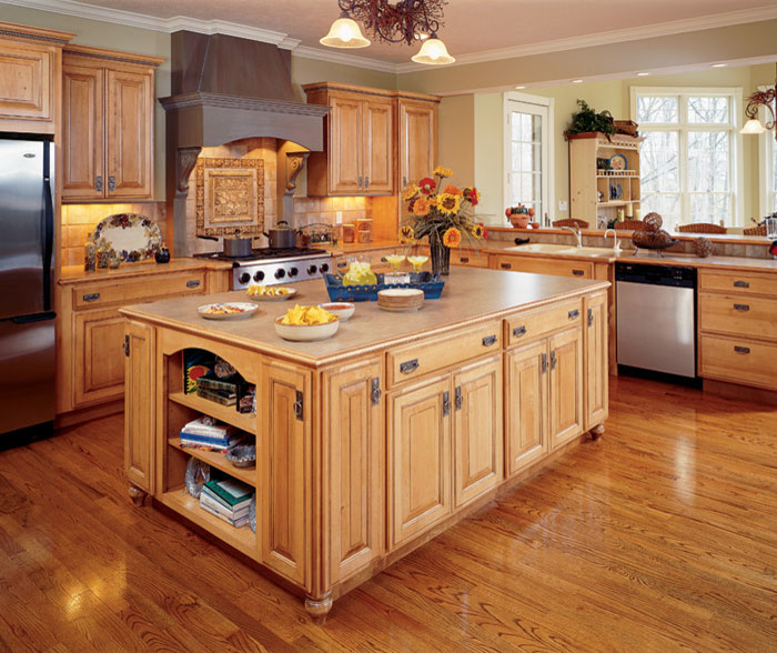 Kitchen - large transitional l-shaped medium tone wood floor and brown floor kitchen idea in Denver with a double-bowl sink, raised-panel cabinets, medium tone wood cabinets, solid surface countertops, brown backsplash, stone tile backsplash, stainless steel appliances and an island