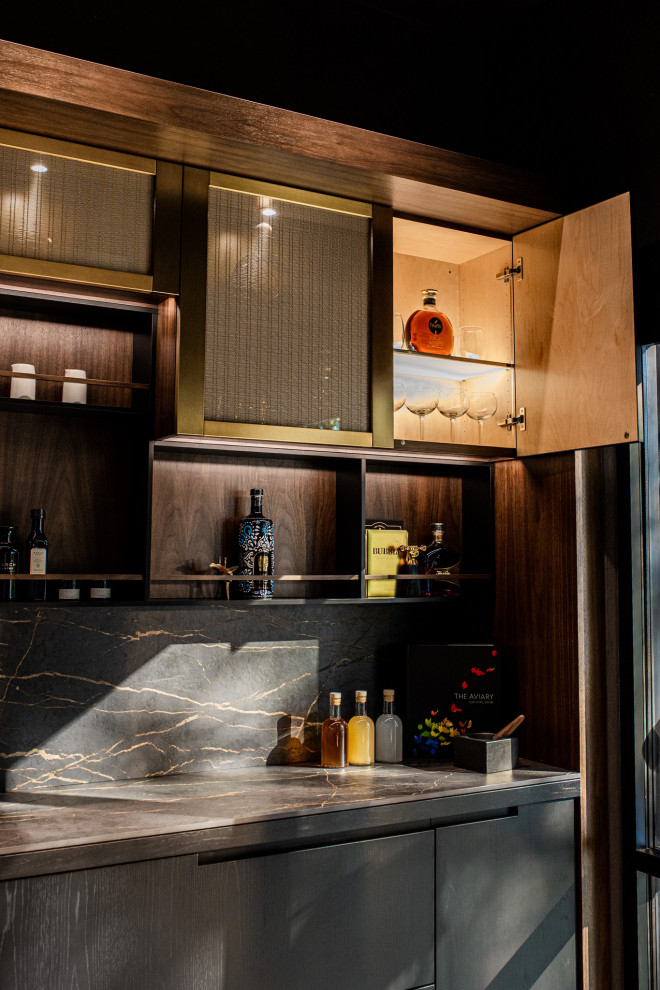 Design ideas for a small modern l-shaped dry bar in San Francisco with no sink, glass-front cabinets, black cabinets, composite countertops, black splashback, engineered quartz splashback and black worktops.
