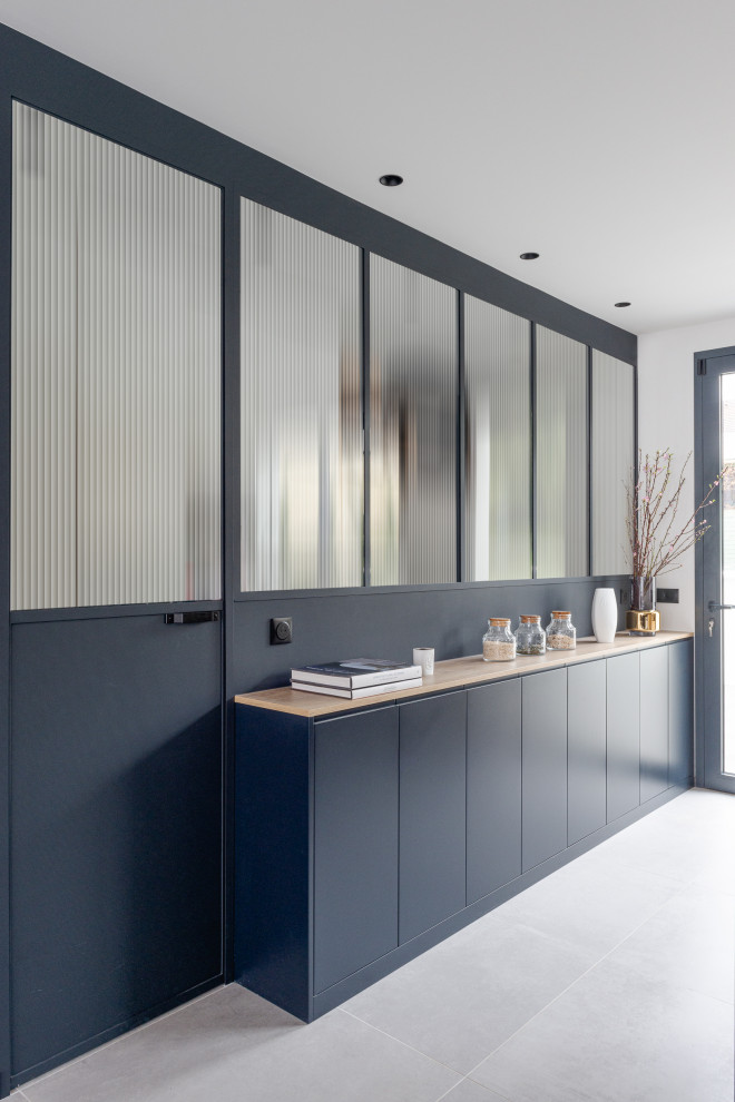 Immagine di una grande cucina ad ambiente unico design con ante lisce, ante nere, top in legno, pavimento con piastrelle in ceramica, pavimento grigio e top beige