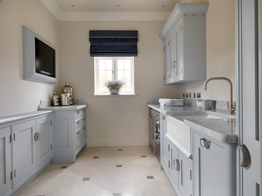 Traditional laundry room in Other with limestone floors and grey walls.