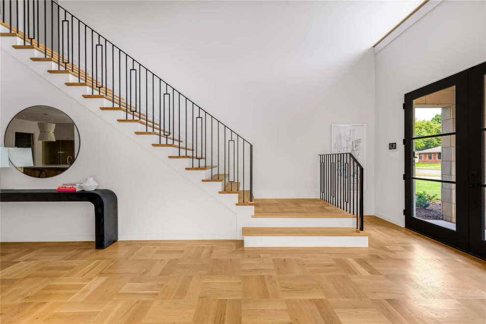 Стильный дизайн: большая угловая деревянная лестница с деревянными ступенями и металлическими перилами - последний тренд