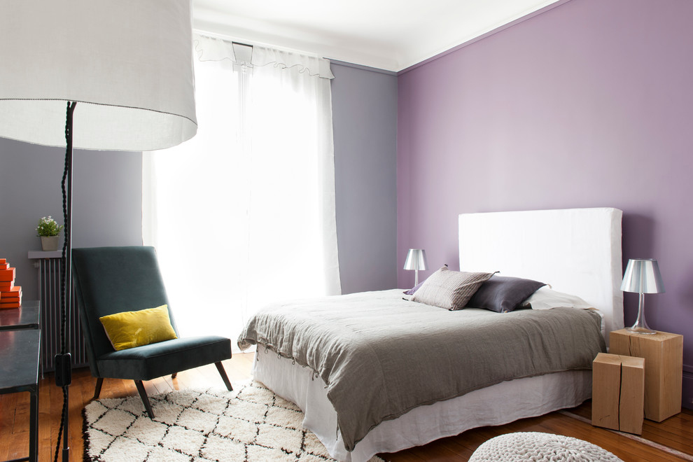 Midcentury bedroom in Paris with multi-coloured walls and medium hardwood floors.
